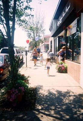 This is the block, and the lady is watering all the plants on the street.