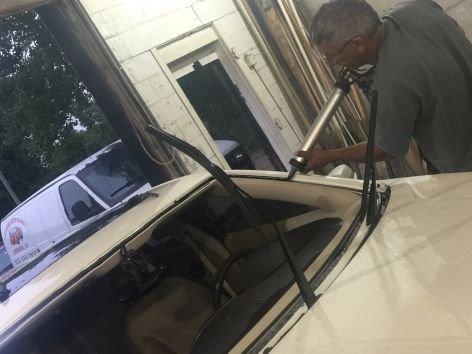 Ramon putting new adhesive on before he places the new windshield on.