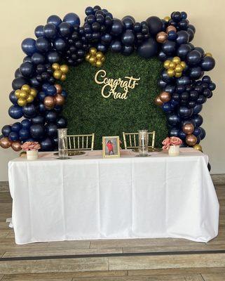 Grad table with grass background and ballon decor on stage