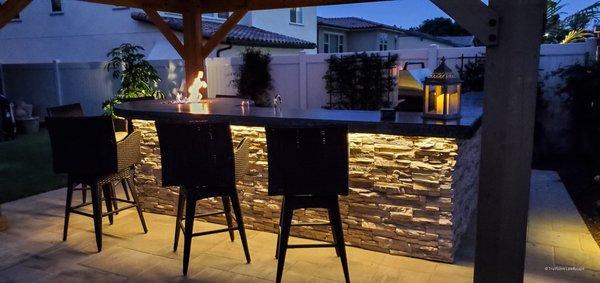 Outdoor BBQ with a custom fire feature integrated into the bar