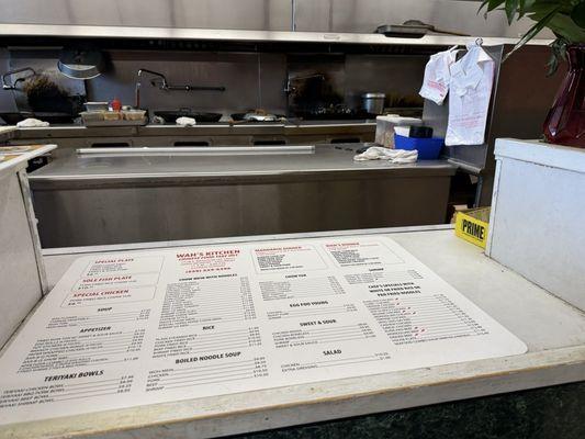 Menu on food pickup counter. View into delightful action and smells of open kitchen.