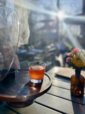 Smoke and Dagger cocktail emerging from the smoke.