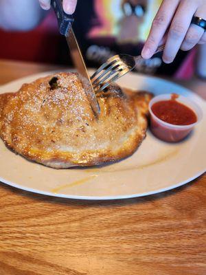 Veggie calzone with added ham and pepperoni.