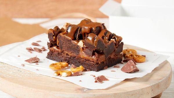 A light textured Brownie topped with buttery caramel, piled high with brownie cubes, toasted pecans and a caramel drizzle.