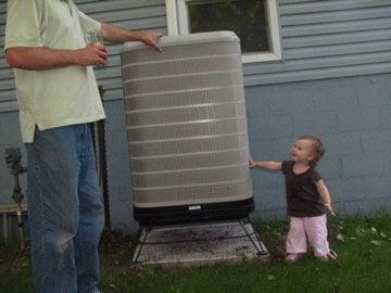 Josh & Chloe next to a Westinghouse heat pump