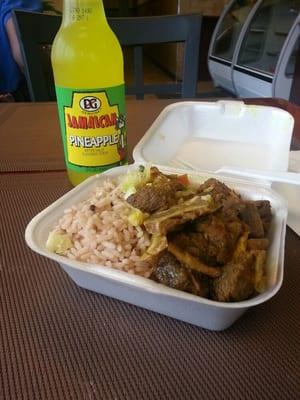 Curry goat with rice and salad & pineapple soda