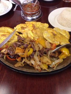 Lean skirt steak with onions peppers and mushrooms.. Plantains and side of white rice