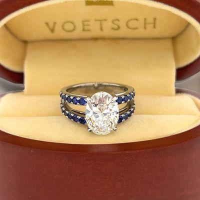 Oval lab grown diamond with blue sapphires set in platinum split shank ring.