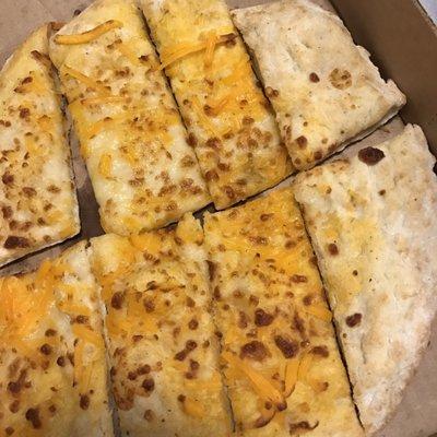 "cheesy garlic bread" topped with "lots" mixed of cheeses and apparently no marinara. garbage bread.