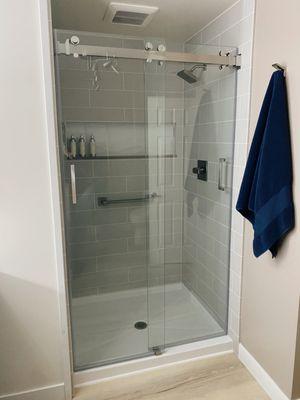 Shower remodel with 6 x 24 tile pattern, frameless sliding shower door, big custom niche, brushed nickel delta fixtures