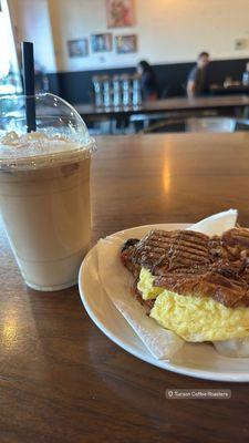 Egg croissant sandwich with bacon and pepper jack. Caramel macchiato iced with whipped cream.