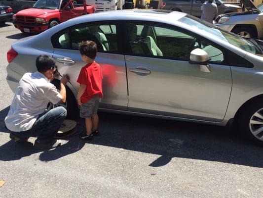 Mr.Henry of showing my son how to add the rubber trim to the door. Also showing the repaired door where we had been hit.