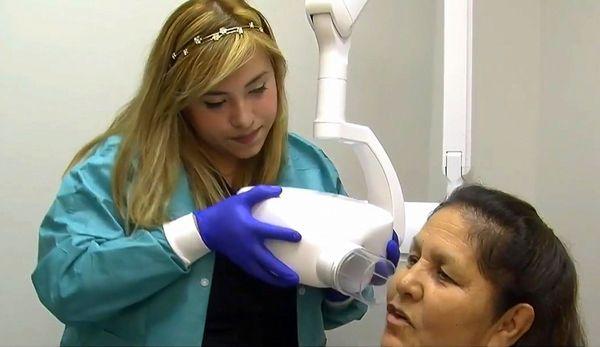 Dental hygienist taking X ray of patient at Dallas dentist Hermosa Dental & Orthodontics