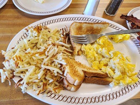 Hashbrowns, scrambled eggs, toast, and bacon