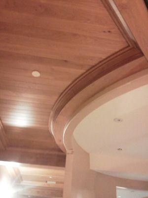 Tongue and groove alder ceiling with built down false beams trimmed with radius crown molding.