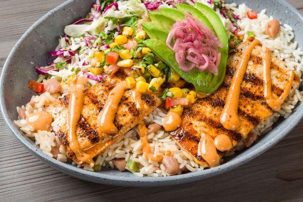 Mahi Mahi Bowl Cali-Style, grilled Mahi, white rice, beans, diced chili mix, with avocado corn salsa, chipotle aioli & pickled onions.