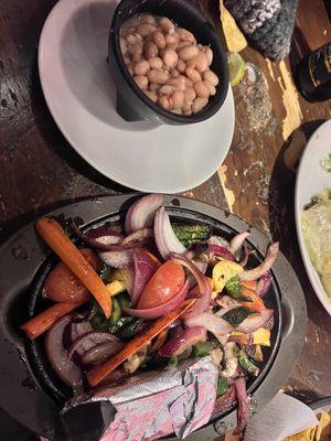 Veggie fajitas. Corn tortillas are in the foil. Beans on the side.