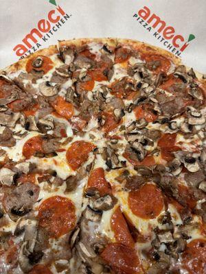 Pizza with pepperoni, sausage, and mushrooms