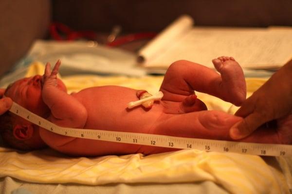 Midwife performing newborn exam after a safe homebirth