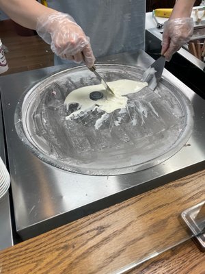 Ice cream being prepared into little cylinders over a freezing cold surface. Unique and fun!