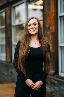 Female dental assistant in Burien, WA standing outside dental office