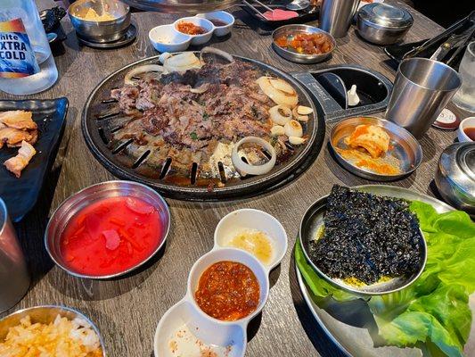 Beef Bulgogi on the grill. Various sides on the table. Part of the Harmony Combo.