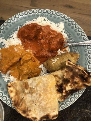 Left: butter chicken over rice, right is chicken tiki masala. Cheesy naan, garlic naan and veggie samosa