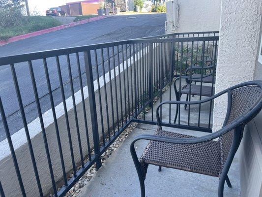 Below grade "balcony" with air conditioner blowing onto the single chair.