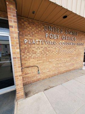 Sign on outside wall for Platteville Post Office