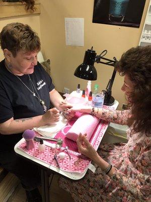 A student doing a no chip manicure on a client