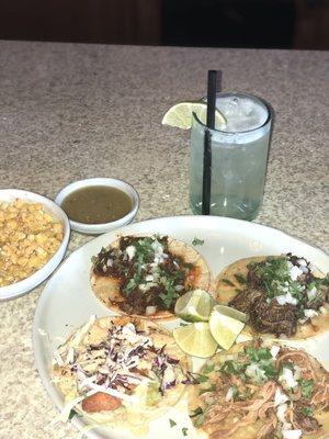 This is baja fish, barbacoa, brisket, and pork carnitas tacos, with a side of corn. I washed it down with a margarita.