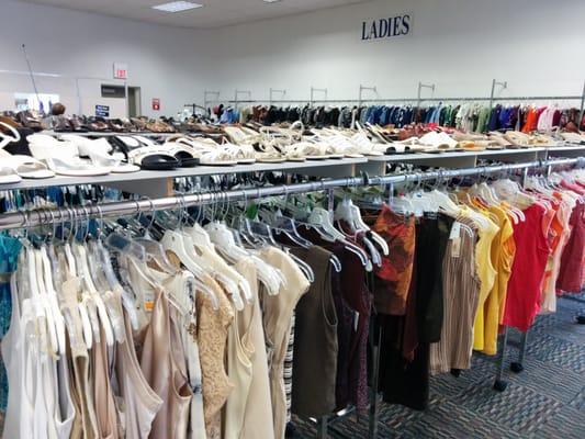 Shoes on shelves over the racks.