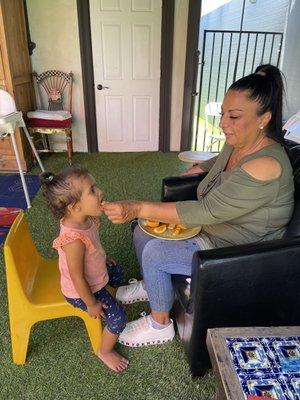 The director feeding a toddler organic vegetables after Nap time.