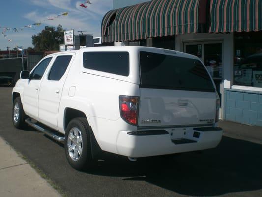 Century fiberglass camper shell custom design for the Honda Ridge-line and Stainless Steel  side step bars.