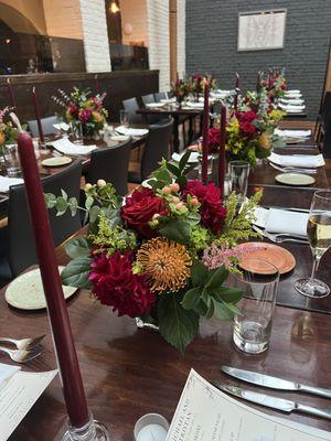 Small centerpieces spaced evenly on a long rectangular table for a wedding