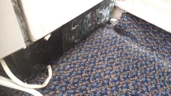 Air conditioner dirty and electrical cords run under the carpet