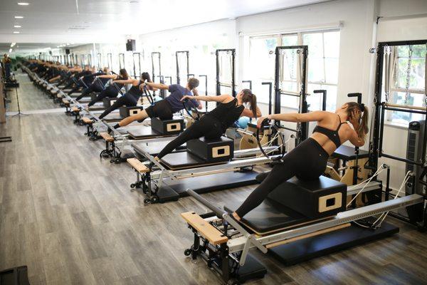 The group Classroom is fully equipped with 10 Merrithew V2 max reformers and Stability Chairs.  In this picture we demonstrate side bends.