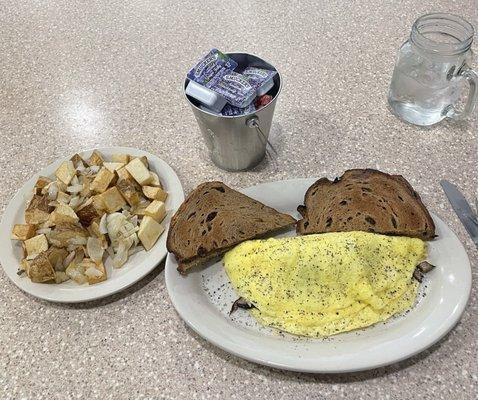 Mushroom and cheese omelette with cinnamon raisin toast with side of home fries with onions.