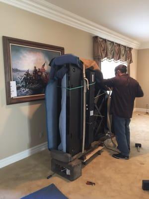 Baby grand piano being professionally moved