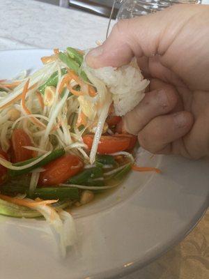 Dipping  my rice into my papaya salad.