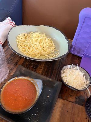 Kids spaghetti with sauce and cheese on the side