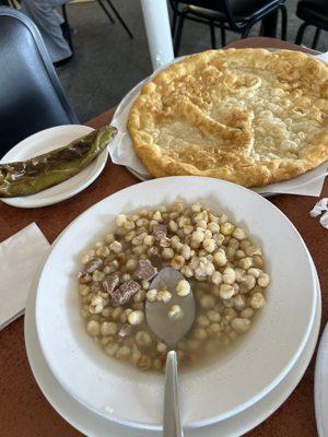 Steamed corn stew with large fry bread and side of whole roasted green chili.