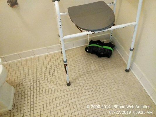 Bathroom. Old and deteriorate metal chair. Also a pair of shoes from a dead resident. Those shoes stayed in there for one whole month.