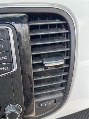 Dirt and dust in the air vents after the "detailing". Disgraceful and careless.