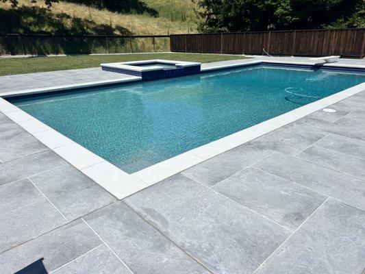 No tear out needed on this pool deck and coping! Square and rectangle design with grays.