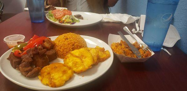 Bottom Carne Frita, tostones, arroz con gandules, alcapurria (fried pork, fried plantains, Puerto Rican rice, stuffed yuca fritters)