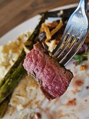 A piece of the medium rare 8oz Center Cut Filet Mignon on a fork getting ready to be savored and enjoyed.