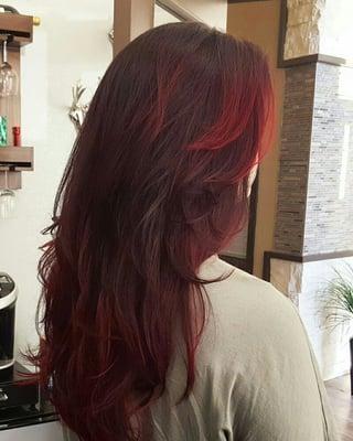 balayage of Red jewel tones with a base color of charcoal & custom long graduation cut.