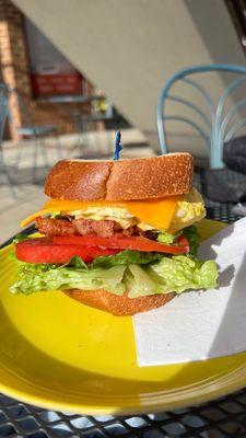 Bacon egg and cheese breakfast sandwich with avocado, lettuce and tomato.