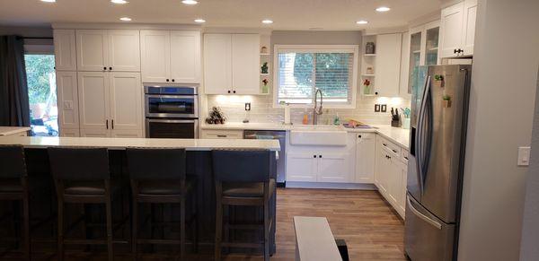 Two toned maple cabinets, dark island & white perimeter. Quartz countertops and a farm house sink in Portland, Oregon!